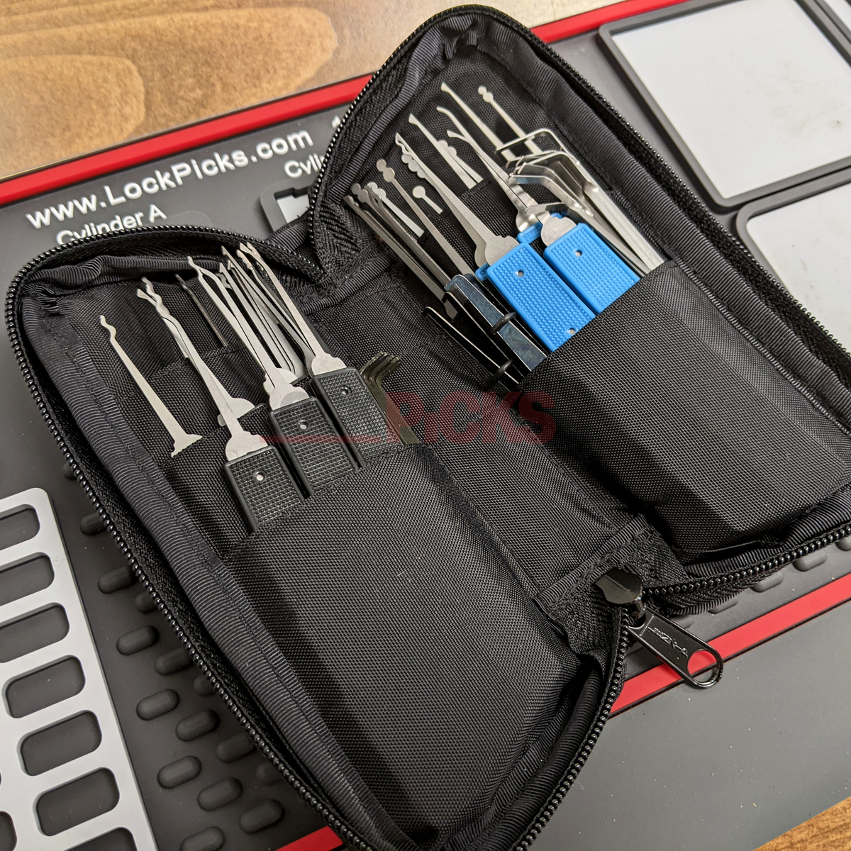 Lock picking tool set in a black case on a wooden surface
